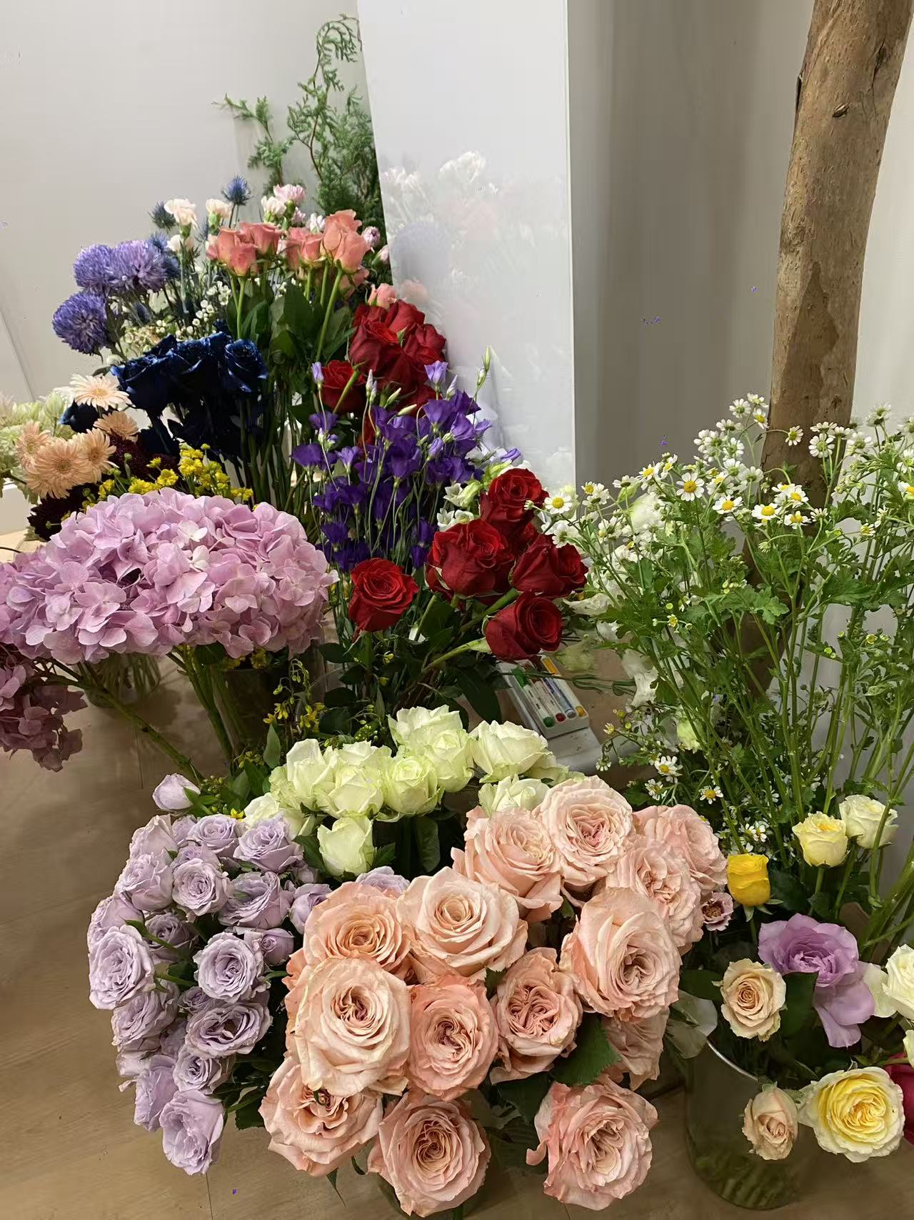 Inside the Maison Ninelle atelier — buckets of fresh roses and hydrangea